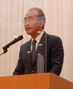 あいさつをする佐川博之代表幹事